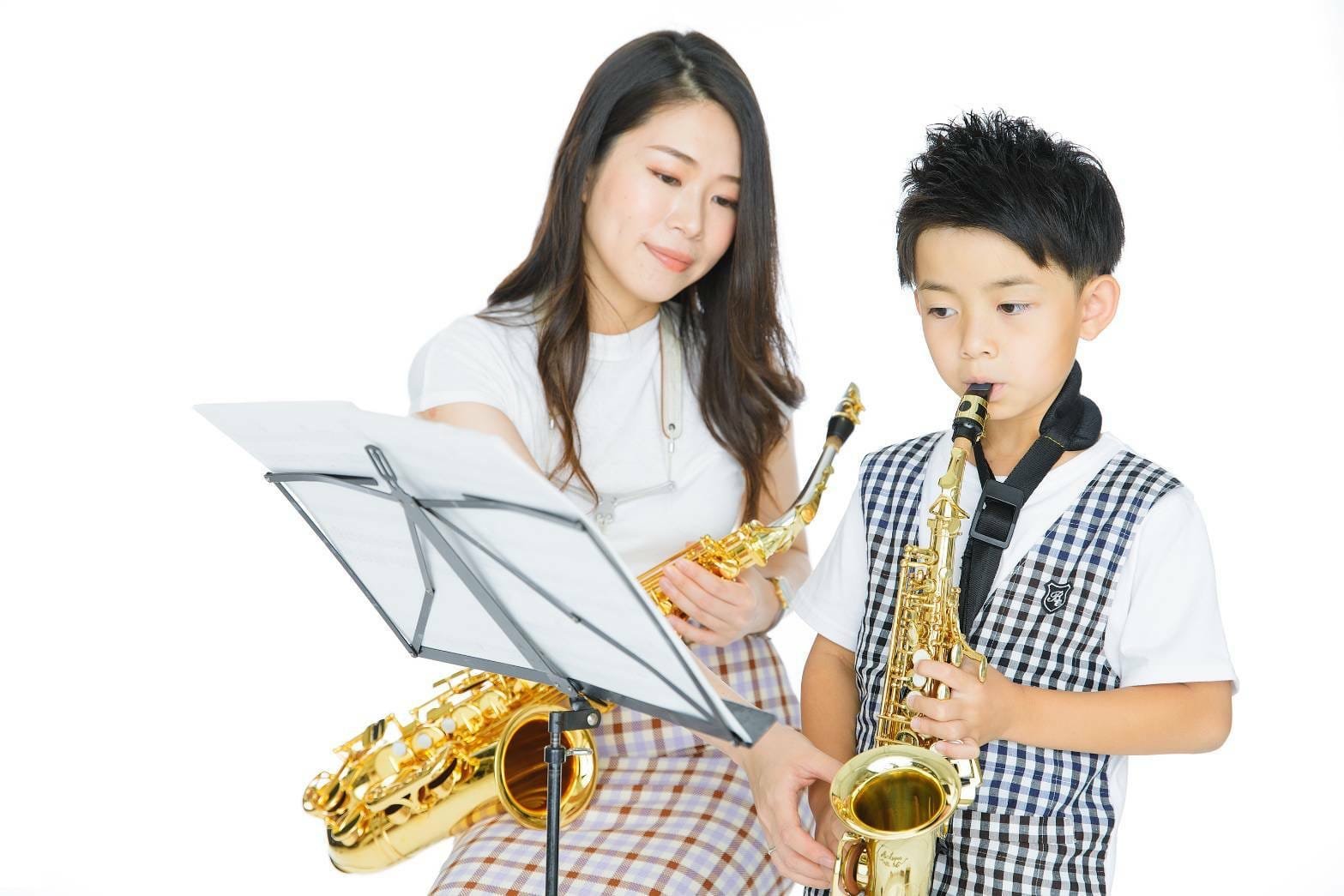 サックスの練習をする男の子と女性